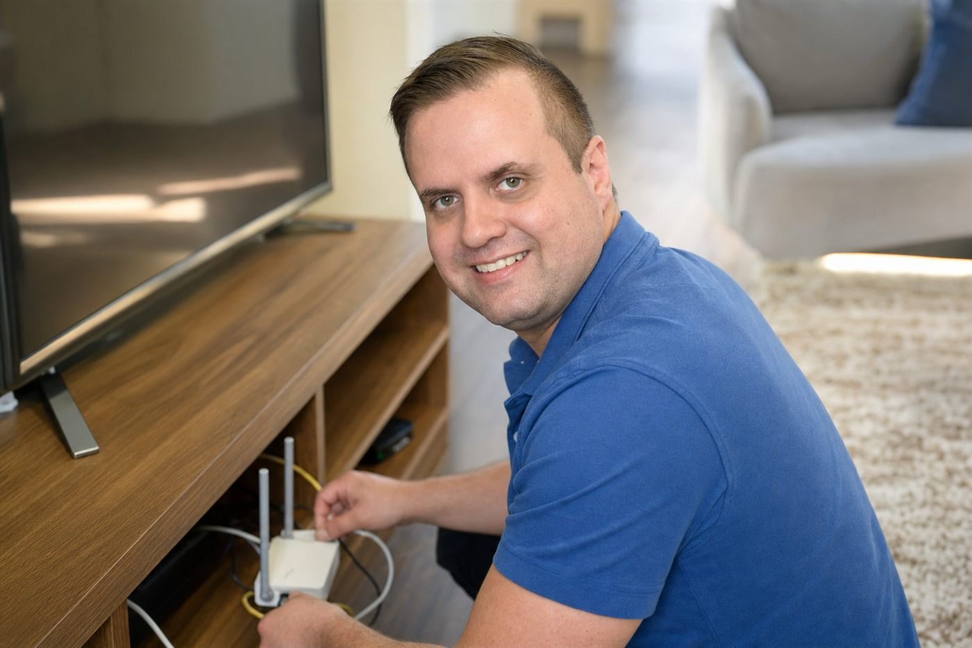 Afford IT technician setting up a WiFi router at the TV cabinet in a Brisbane living room